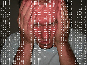Man with head in hands, behind foreground of ones and zeros like matrix