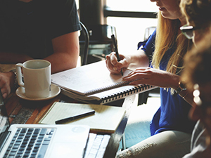 Woman at coffee shop taking notes in meeting